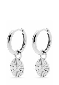 Silverringar med en solstråle-hänge som har en central ädelsten. Slät, glänsande yta med en texturerad design på hängena.