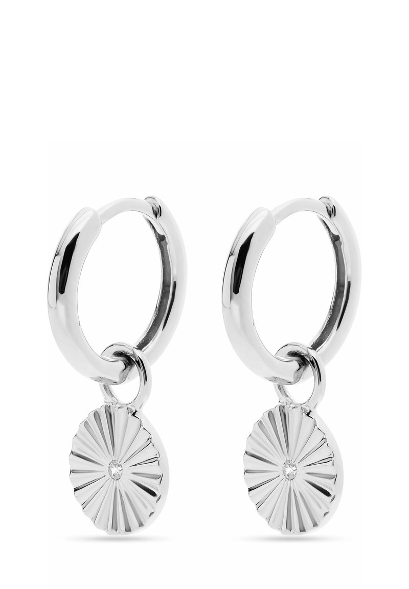 Silverringar med en solstråle-hänge som har en central ädelsten. Slät, glänsande yta med en texturerad design på hängena.