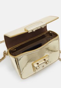 Kultainen metallinhohtoinen käsilaukku, jossa on sileä pinta, ketjuhihna, jämäkkä muoto ja ylhäällä oleva turvallinen lukitus.