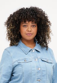Light blue denim jacket featuring two chest pockets, silver snap buttons, and a classic collar design. Soft texture and tailored fit.