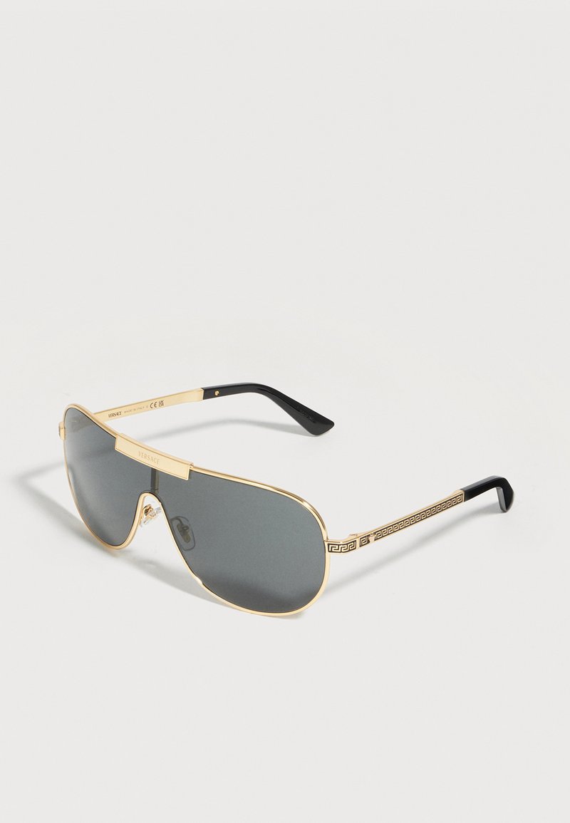 Gold-framed aviator sunglasses with dark lenses, black temple tips, and decorative Greek key pattern on the arms.