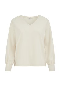 V-nyakú, hosszú ujjú felső világos krémszínben, texturált anyagból, enyhén pöndörödő ujjakkal és testhez simuló mandzsettákkal a kényelmes viseletért.