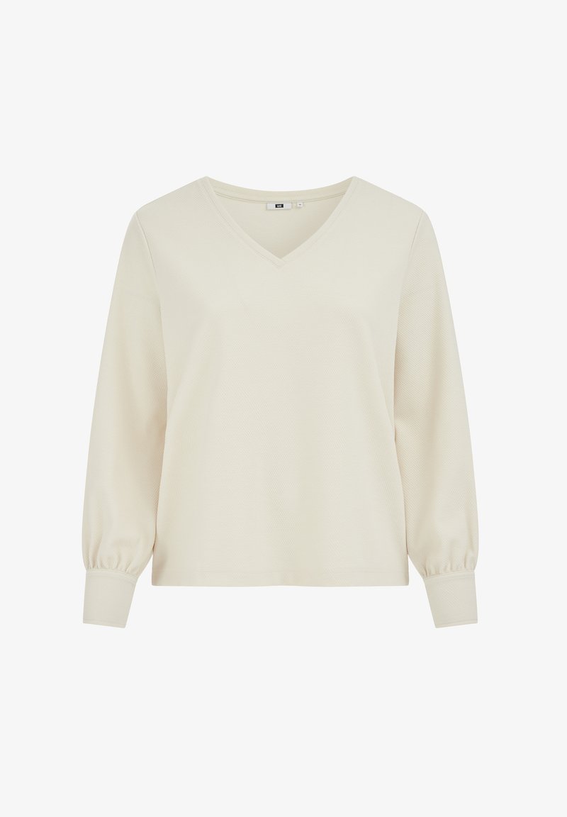 V-nyakú, hosszú ujjú felső világos krémszínben, texturált anyagból, enyhén pöndörödő ujjakkal és testhez simuló mandzsettákkal a kényelmes viseletért.
