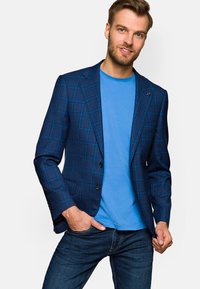 Granatowa marynarka w kratę o dopasowanym kroju, z dwoma guzikami z przodu, klapami w kształcie notcha oraz gładką teksturą na jasnoniebieskiej koszulce.