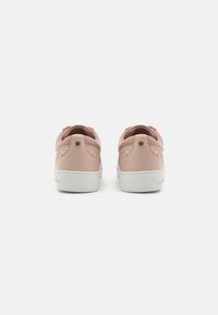 Sneaker sintetiche rosa con finitura liscia, suole in gomma bianche, colli imbottiti e logo in rilievo sul tallone. Design semplice, forma low-top.