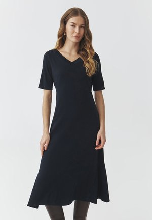 Abito nero con scollo a V, maniche corte, forma ad A svasata, tessuto morbido, lunghezza fino al ginocchio e dettagli di drappeggio sottili.