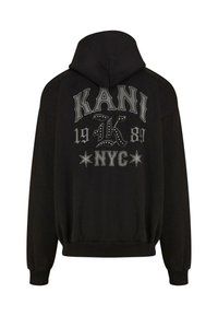 Black hooded sweatshirt featuring large graphic text "KANI 1989 NYC" on the back, accented with stars and decorative studs. Soft fabric, relaxed fit.