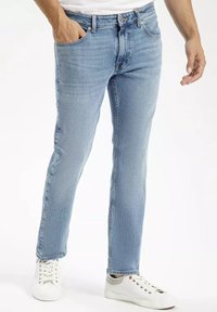 Jasnoniebieskie dżinsy o prostym kroju, pięć kieszeni i klasyczne wykończenie, w zestawieniu z białymi sneakerami. Gładka faktura, casualowy design.