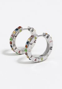 Pendientes de aro de plata con piedras de colores y letras grabadas alrededor de los bordes. Diseño circular con textura brillante y cierre seguro.