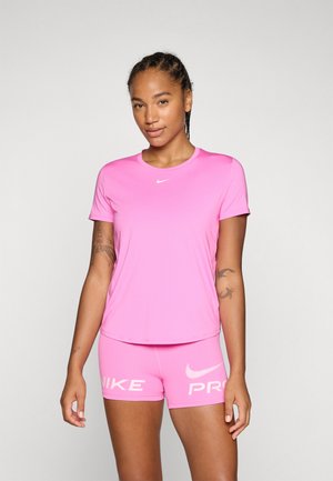 Camiseta deportiva rosa de Nike con mangas cortas y cuello redondo, combinada con pantalones cortos rosa a juego que cuentan con la marca blanca de Nike.