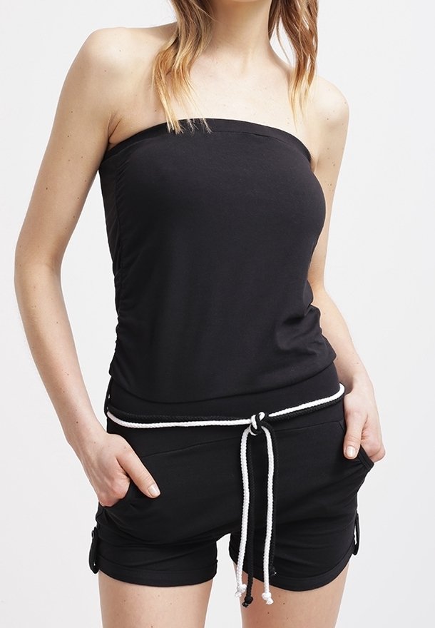 Top sin tirantes negro con diseño ajustado, combinado con pantalones cortos negros que tienen un cordón blanco. Textura suave con un aspecto casual.