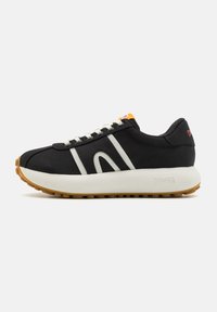 Schwarzer Sneaker mit weißen Akzenten, dicker weißer Sohle, strukturiertem Gummigummi-Außensohle und orangefarbenem Etikett auf der Zunge. Verfügt über einen klassischen Schnürverschluss.