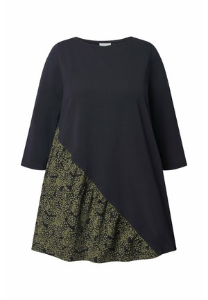 En mørk marineblå kjole med trekvartærmer, der har et struktureret grønt mønsterpanel diagonalt over den nederste halvdel.