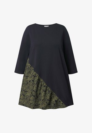 Tumma laivastonsininen mekko, jossa on kolme neljäosaa hihoista ja jonka alaosassa on vinosti kankaan poikki kulkeva teksturoitu vihreä kuvioitu paneeli.