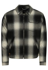 Kariertes Jackett in Schwarz und Weiß, mit Kragen, frontalem Reißverschluss, zwei Seitentaschen und einer linken Brusttasche. Strukturierte Stoffoberfläche.