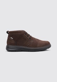 Bota de tobillo de cuero marrón con suela de goma negra, cordones en la parte delantera y tirador en un fondo gris claro.