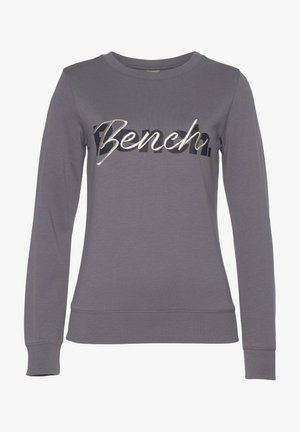 Gray sweatshirt featuring long sleeves, a crew neck, and a prominent "Bench" logo in metallic silver and black. Soft, smooth texture.