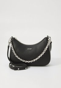 Black leather handbag with a pebbled texture, curved shape, silver chain strap, and zip closure. Features DKNY branding on the front.