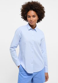 Camicia button-up azzurro chiaro con maniche lunghe, realizzata in tessuto liscio. Presenta un colletto, orlo arrotondato e dettagli dei bottoni sottili.