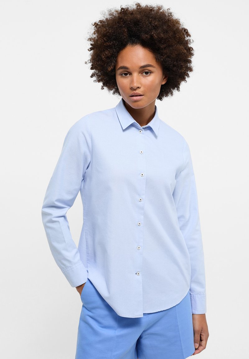Camicia button-up azzurro chiaro con maniche lunghe, realizzata in tessuto liscio. Presenta un colletto, orlo arrotondato e dettagli dei bottoni sottili.