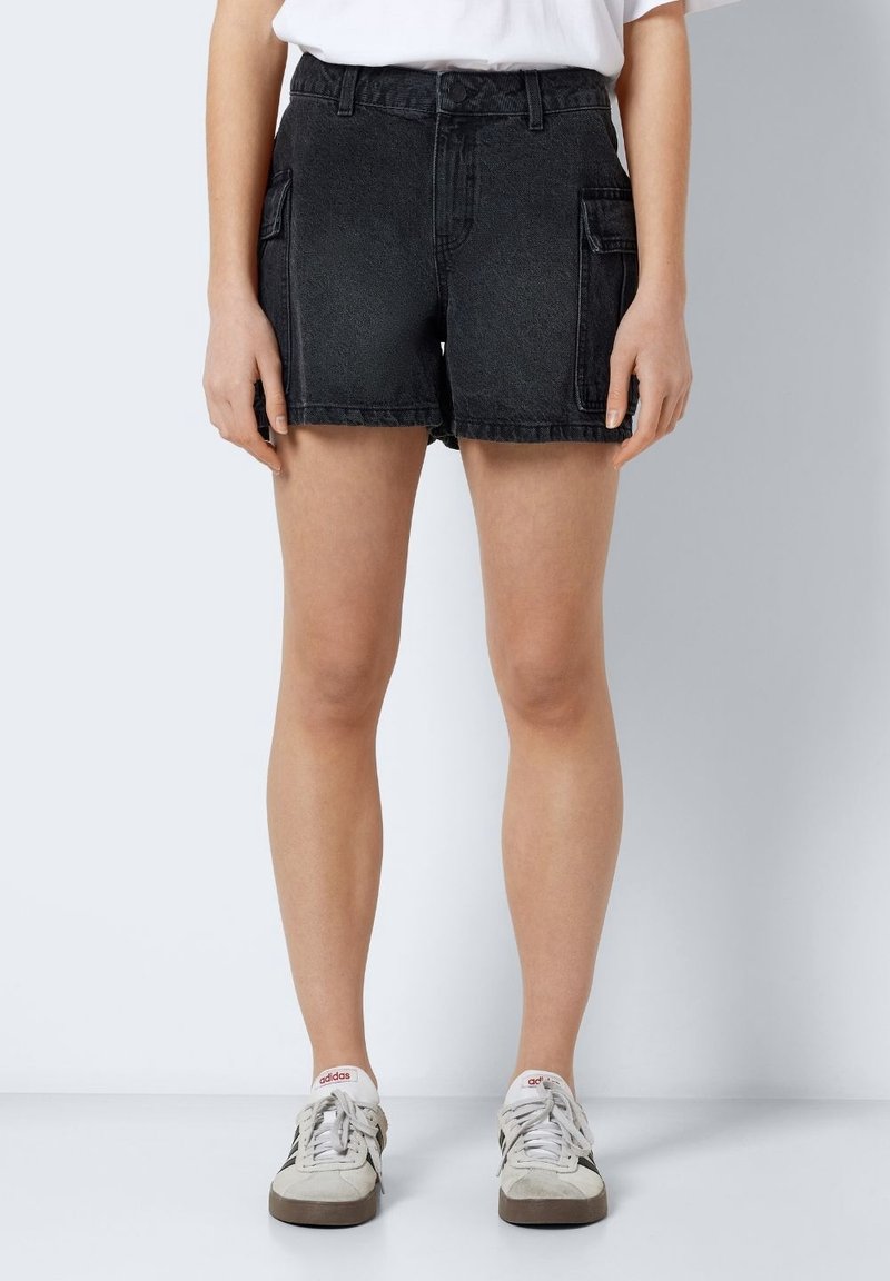 Schwarze Jeans-Shorts haben eine hohe Taille, Seitentaschen und einen lässigen Schnitt. Der Stoff hat eine leicht abgewetzte Struktur.