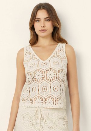 Lace tank top made of woven fabric, featuring a hexagonal pattern, a V-neckline, and a cropped fit in a light beige color.
