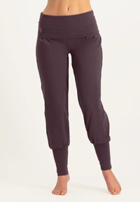 Dunkelviolette Sporthose mit breitem Bund, weichem Stoff, schmal zulaufenden Bündchen und seitlichen Taschen. Mit dezentem Logo am Bund.