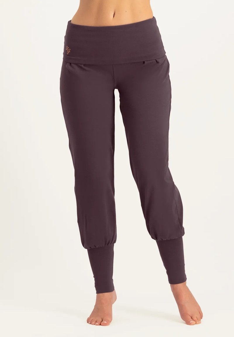 Dunkelviolette Sporthose mit breitem Bund, weichem Stoff, schmal zulaufenden Bündchen und seitlichen Taschen. Mit dezentem Logo am Bund.