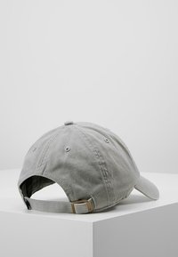 Gray cotton baseball cap with a curved brim, adjustable strap, and six-panel design; features ventilation holes on the crown.