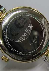 Timex wristwatch back features stainless steel, gold-tone accents, water resistance to 30 meters, and model SR626SW CELL designation.