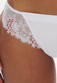 Weiße Unterwäsche mit durchsichtigen Spitzenpaneelen, die mit kunstvollen rosa Blumenstickereien und gewellten Kanten verziert sind. Glattes Material mit einer weichen Textur.