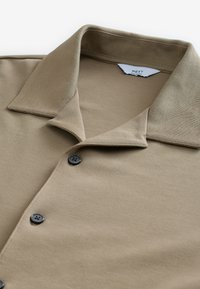 Korte mouwen khaki poloshirt van zacht katoen, met een puntige kraag, zwarte knopen en een gestructureerde stofafwerking.