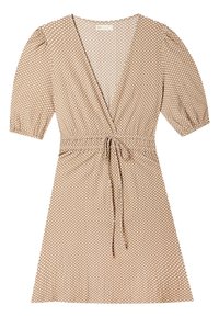 Robe portefeuille beige à pois blancs, manches courtes bouffantes, décolleté en V et ceinture à nouer à la taille.