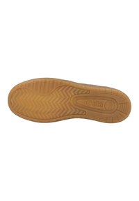 Semelle en caoutchouc avec un motif en chevrons texturé et un détail de logo. Couleur : beige avec une finition lisse et une forme arrondie.