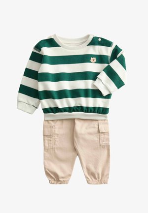Sudadera de algodón a rayas verdes y blancas con un emblema de oso, combinada con pantalones cargo de algodón beige con puños elásticos y bolsillos.
