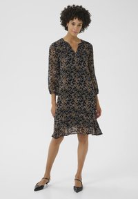 Navyblaues Blumenkleid mit transparenten Ärmeln, V-Ausschnitt und Rüschensaum. Besitzt ein zartes gold- und cremefarbenes Blumenmuster.