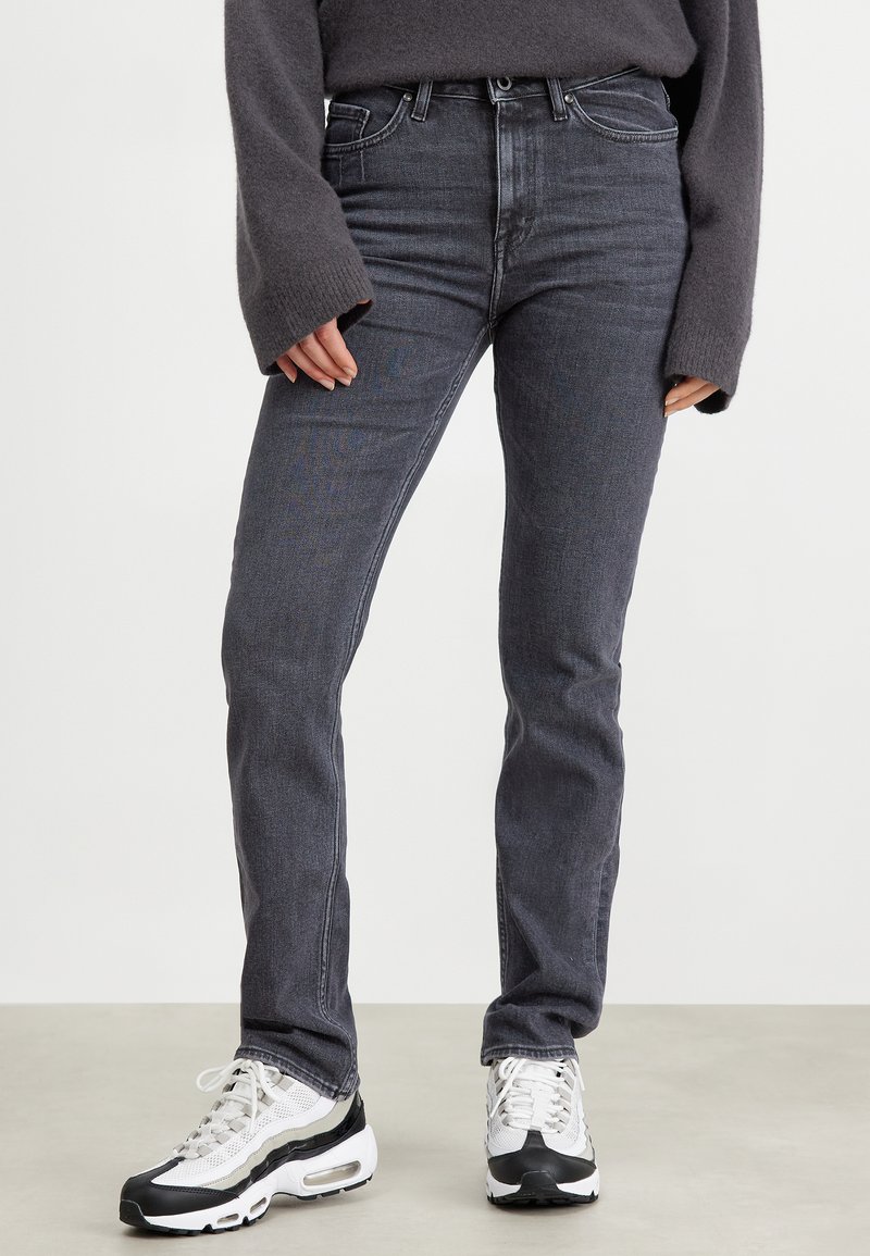 Jasno szare dżinsy slim-fit, z klasycznym pięciopocketowym designem, dyskretnym przeszyciem i średnim stanem.