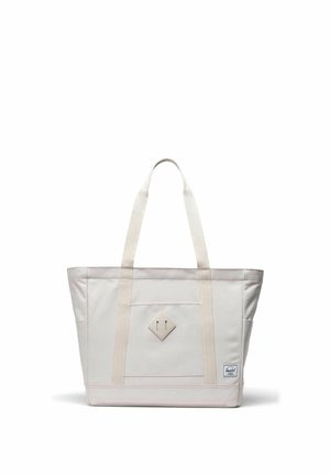 Sac fourre-tout en toile blanc cassé avec double bandoulière, poche avant, patch en forme de losange et petite étiquette de marque en bas à droite.