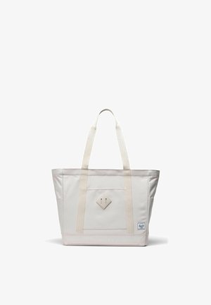 Sac fourre-tout en toile blanc cassé avec double bandoulière, poche avant, patch en forme de losange et petite étiquette de marque en bas à droite.