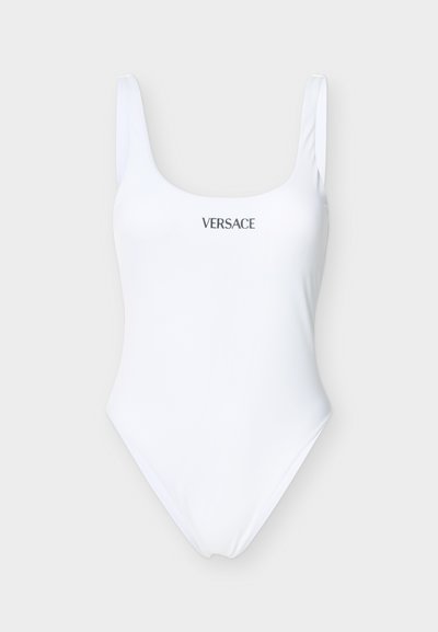 Λευκό ολόσωμο μαγιό με φαρδιές τιράντες και το λογότυπο «VERSACE» σε μαύρο, κεντραρισμένο στο στήθος, πάνω σε ανοιχτό γκρίζο φόντο.