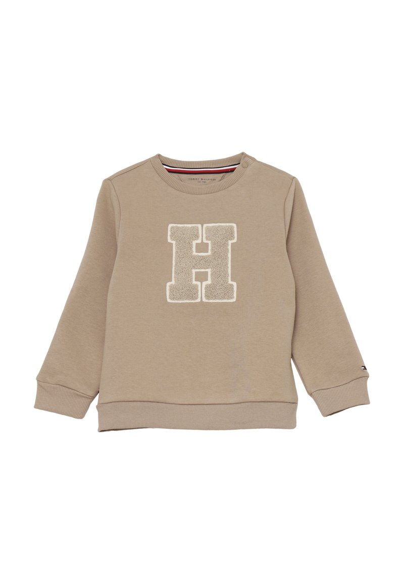 Felpa beige a maniche lunghe per bambini con polsini e orlo a costine, caratterizzata da una grande "H" in rilievo sulla parte frontale e un bottone a scatto vicino al collo.