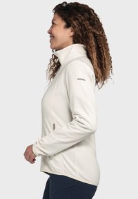 Weiße Fleecejacke mit hohem Kragen, seitlichen Reißverschlusstaschen und minimalistischem Design. Mit dem "Schoeffel"-Logo auf der linken Schulter.