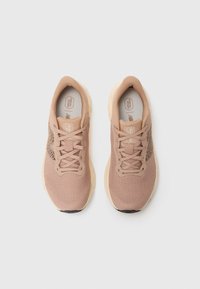 Light pink athletic shoes with a mesh upper, lace-up front, and a textured sole featuring a contrasting black section. Durable and lightweight design.