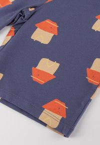 Cotton fabric featuring a navy background with repeating patterns of stylized houses in beige and red, accented with yellow lines.