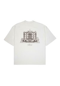 White cotton t-shirt featuring a detailed brown architectural illustration of a building on the back, with the text "Palace Grand Resort" below.