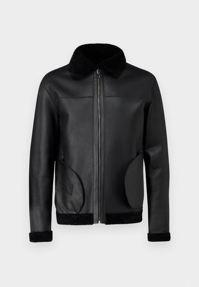 Veste en cuir noir avec fermeture éclair à l'avant, col en fausse fourrure et accents texturés. Présente deux poches latérales courbées et des poignets côtelés.