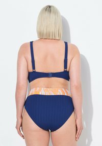 Blau gestreifter Bikini mit einem orangefarbenen, marmorierten Bund. Verstellbare Träger und ein Verschluss am Rücken. Design mit hoher Taille.