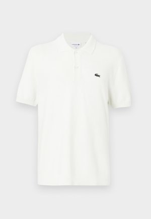 White polo shirt made of smooth cotton fabric with a classic collar, three-button placket, and a small green crocodile logo on the chest.