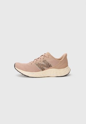 Lys rosa treningsko med mesh-overdel, leopardmønstrete detaljer, gummisåle og teksturert design. Rund tå og snøring.