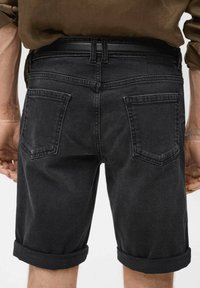 Schwarze Denim-Shorts mit umgeschlagenem Saum, ausgestattet mit zwei Gesäßtaschen und einem glatten Bund. Subtile Nähte ergänzen das Design.